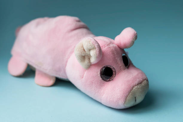 istock Plush toy pink pig on a blue background. Indoors, day light Front view. 1320968589