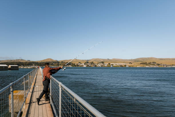 istock Man fishing on pier 1320970566