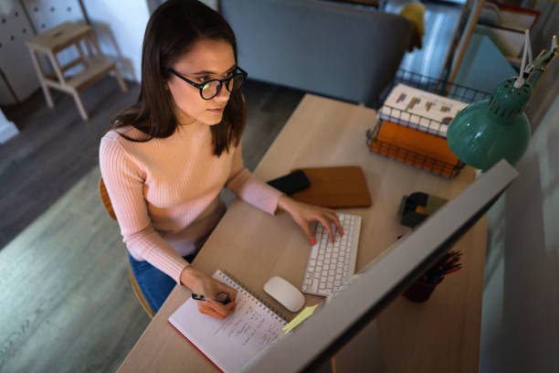 istock High-angle view of a young woman tracking and trading stocks on a computer 1320972342