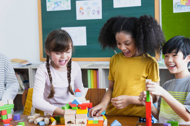 istock group of Diversity of school students playing wooden blocks in classroom. Elementary school children enjoy learning together. Learn to work as a team. Back to school concept 1320972373