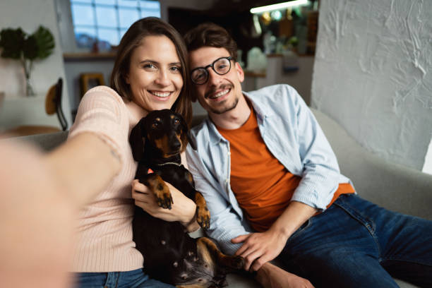 istock Young couple with a dog taking a selfie 1320972415