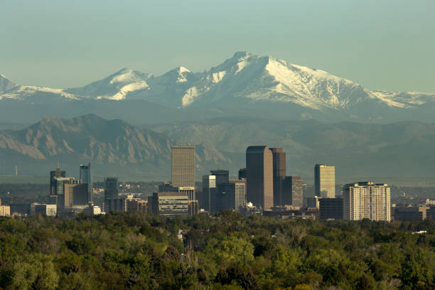 Denver Colorado downtown skyscrapers Boulder Flatirons red rocks Longs Peak Rocky Mountains The snow covered Rocky Mountains and Longs Peak rises over the Boulder Flatirons and Downtown Denver skyscrapers, hotels, office and apartment buildings. front range mountain range stock pictures, royalty-free photos & images