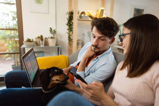 istock Young couple tracking and trading stocks while using a laptop and a smartphone at home 1320972498