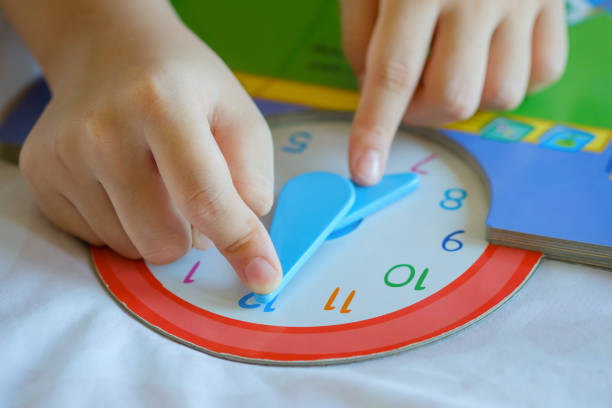 istock kid play telling time game, young children to learn how to read an analog clock. 1320972500
