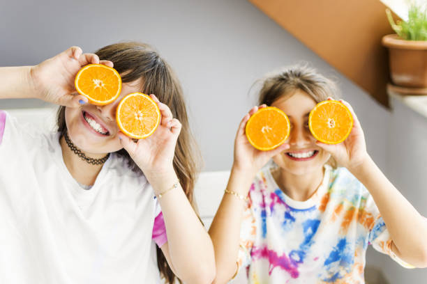 istock Beautiful girls posing with orange 1320974163