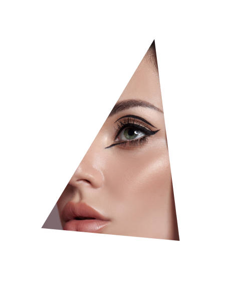 istock Beauty makeup women, eye brows eyelashes and lips in a triangular hole paper white background. Professional beauty makeup, place for text, copy space 1320974189