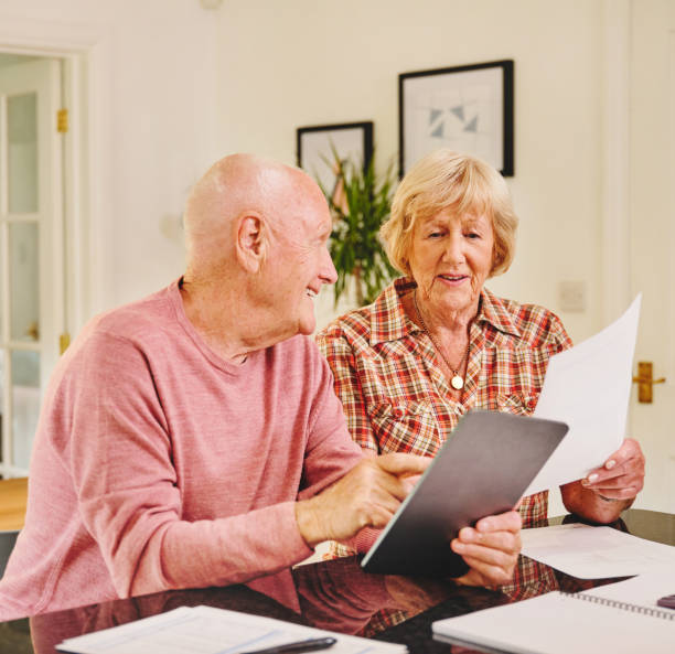 istock Shot of a senior couple using a digital tablet while through paperwork together at home 1320976232