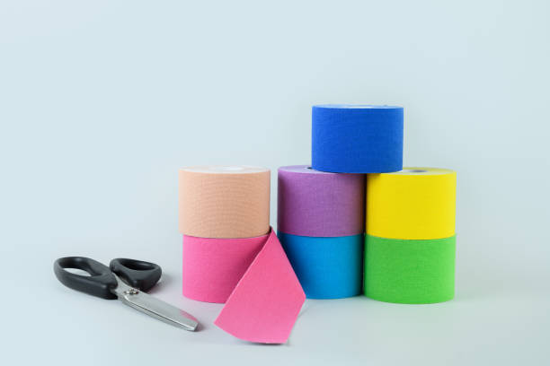 istock Rolls kinesiology tape and scissors on vertical blue background. 1320976430