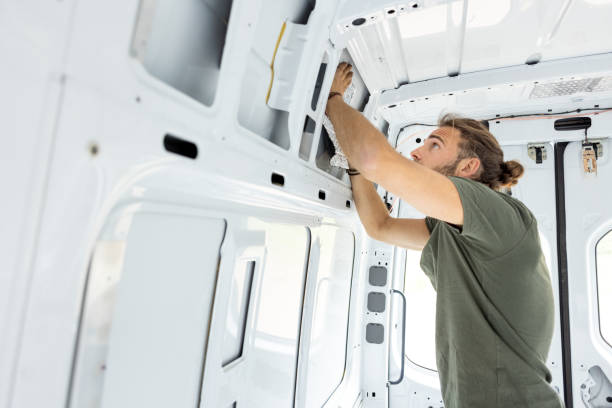 istock Man puts insulation on the inside of a van 1320979064