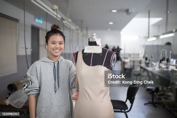 Asian Chinese Female Fashion College Student Doing Clothing Project At College Workshop Smiling Facing Camera Stock Photo - Download Image Now