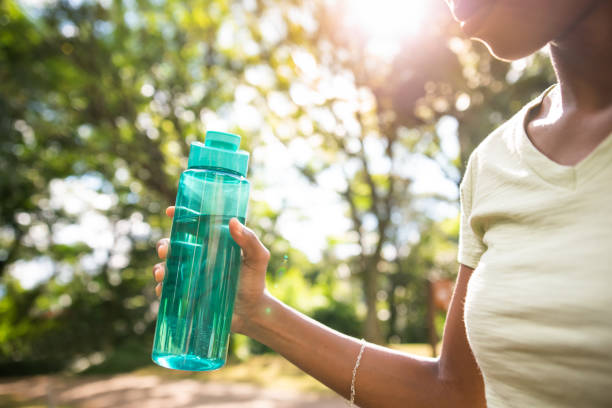 istock woman drinking water from the bottle 1320985908