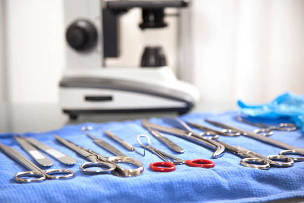 Medical - autopsy or surgical tools.  Microscope in background with surgical tools in foreground. stock photo