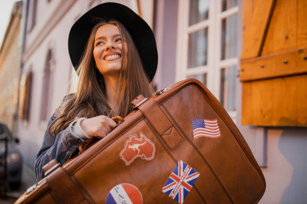 istock Young female tourist holding retro suitcase 1320986632