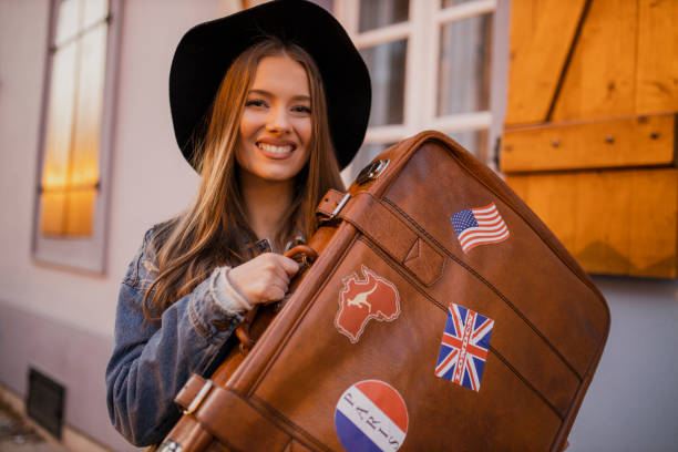 istock Young female tourist holding retro suitcase 1320987874