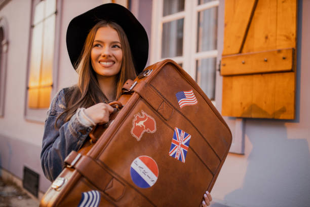 istock Young female tourist holding retro suitcase 1320988007
