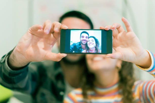 istock Capturing bright moments. Joyful young loving couple making selfie on camera. New technology trends and friendship concept. 1320988182