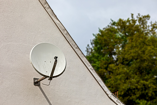 small satellite dish on a house wall