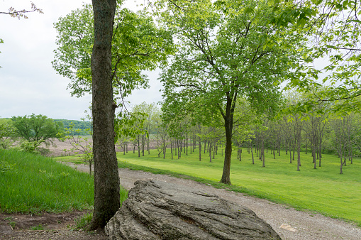 May 17, 2021 - Grand River Township, Missouri, USA: This rock, called Preacher's Rock, and cultivated pecan orchard are part of Adam-ondi-Ahman, owned and maintained by the Church of Jesus Christ of Latter-day Saints.  This is a sacred spot for church members. Joseph Smith prophesied this would be a gathering place in the last days. This shot was taken on a wet spring day with cloudy skies in the background but lush greenery covering and surrounding the site.