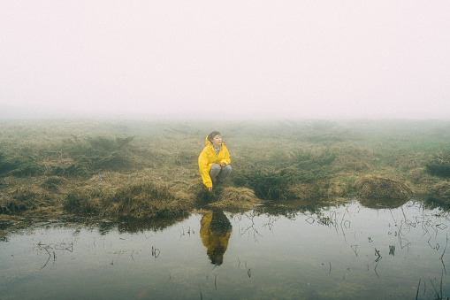 Photo of a young woman in the nature on a foggy day