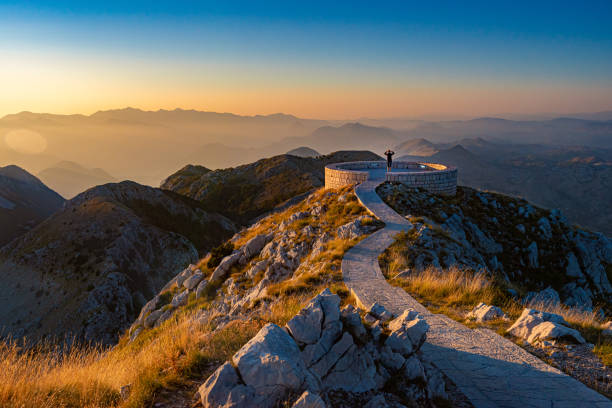 cena do pôr do sol no mausoléu de njegos na montanha lovcen, montenegro, europa. uma pessoa olhando para as montanhas. - lovcen - fotografias e filmes do acervo