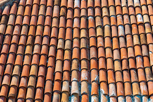Old tiled roof of house in Europe. Close up view with details.