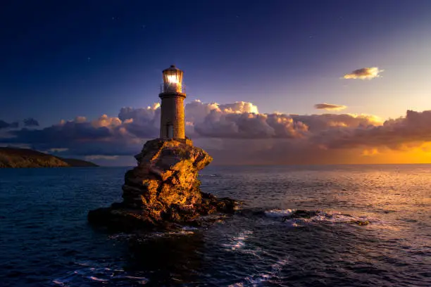 Photo of The beautiful Lighthouse Tourlitis of Chora at night. Andros island, Cyclades, Greece