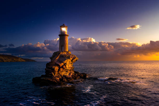 o belo farol tourlitis de chora à noite. ilha andros, cíclades, grécia - sea aegean sea night illuminated - fotografias e filmes do acervo