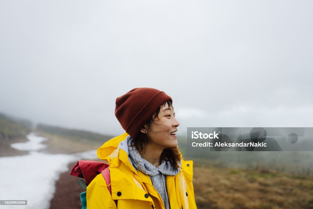 Hike through the beautiful nature Photo of a young Asian woman in the nature on a cold, foggy day Winter Stock Photo