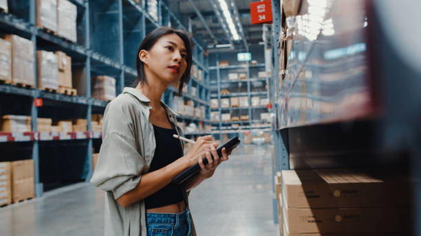 istock Attractive young Asia businesswoman manager looking for goods using digital tablet checking inventory levels standing in retail shopping center. 1320995379