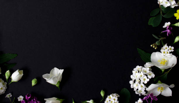 istock Floral frame made of different spring flowers on black background. Flowers flat lay. Space for text 1320995608