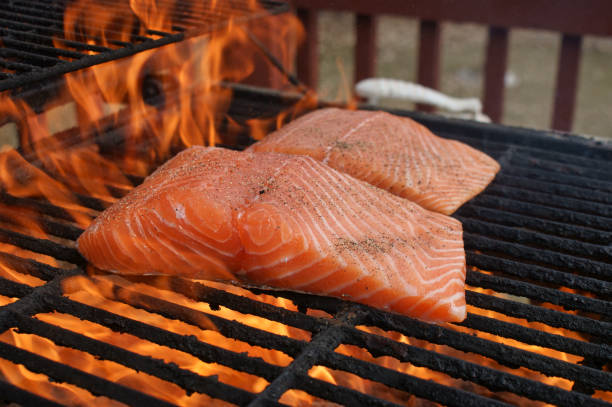 salmón cocinando en llama directa en la parrilla afuera con la piel de condimento hacia abajo seared - smoked salmon cooking copy space food fotografías e imágenes de stock