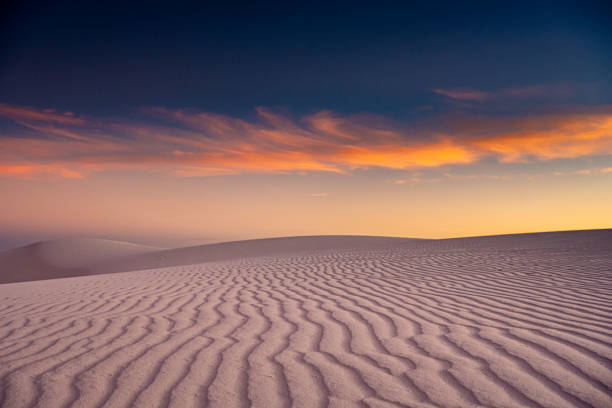 istock Orange and Blue Skies Over White Sand Dune Lines 1320998314