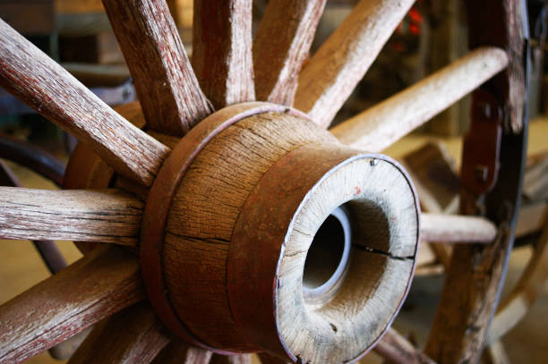 明るい夏の日に乾燥した分割木材と錆びた金属バンドを強調するアンティークワゴンホイール選択的に焦点を当てた - wagon wheel ストックフォトと画像