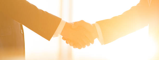 istock The businessmen handshake on the sunny background 1320999997