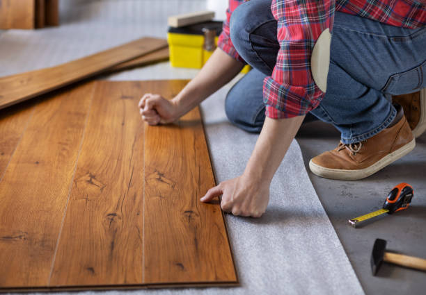 istock Man worker installing laminate flooring. Wooden laminate floor plank and tools 1321000860