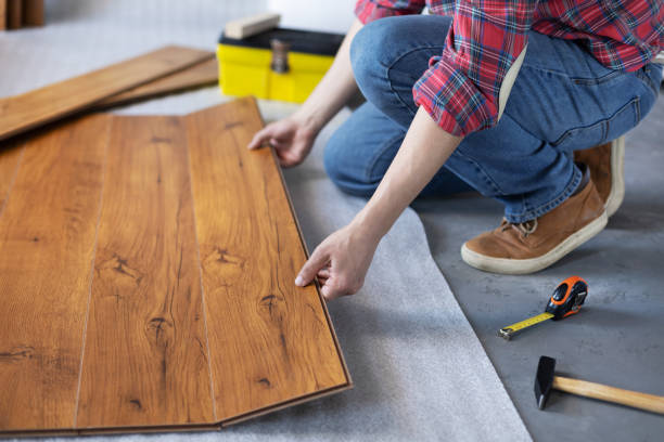 istock Man worker installing laminate flooring. Wooden laminate floor plank and tools 1321000885