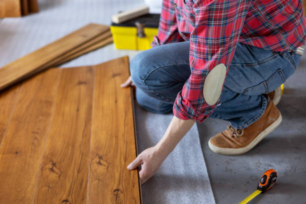 istock Man worker installing laminate flooring. Wooden laminate floor plank and tools 1321000927