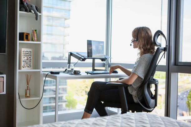 istock Rear view of smiling freelance worker having a videocall while sitting on office chair during daytime 1321004674