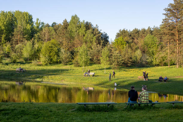 People relax around the glacial Seskiukas lake in Seskines Ozas park, Vilnius, Lithuania Vilnius, Lithuania - May 26, 2021: People relax around the glacial Seskiukas lake in Seskines Ozas park, Vilnius, Lithuania. eschar stock pictures, royalty-free photos & images