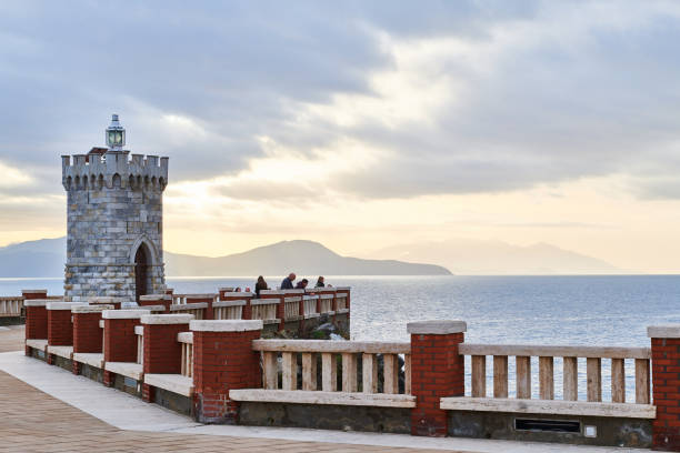 istock People on embankment with lighthouse in evening 1321005747