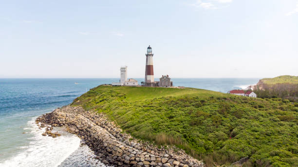 istock White lighthouse with brick on the ocean with a green lawn 1321005856