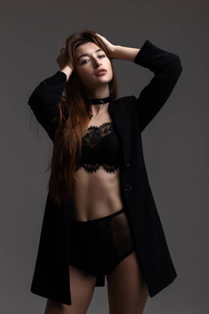 istock Model in total black posing on grey background in studio. Fashion concept. 1321008879