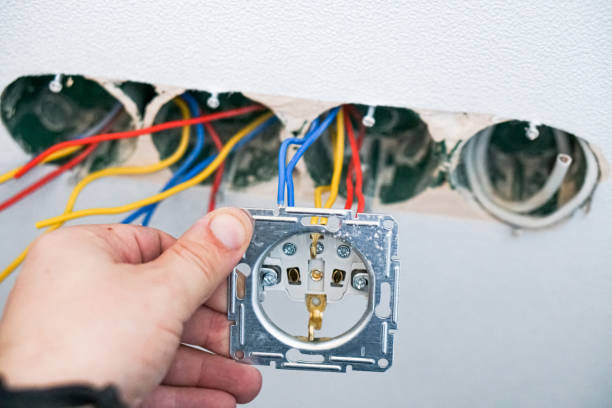 istock Hands of electrician installing socket in gypsum wall 1321008984