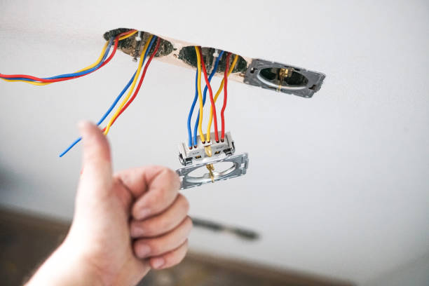 istock Hands of electrician installing socket in gypsum wall 1321009046