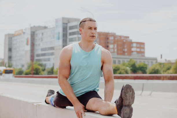 istock Sport man sitting in twine pose on a bridge 1321009771