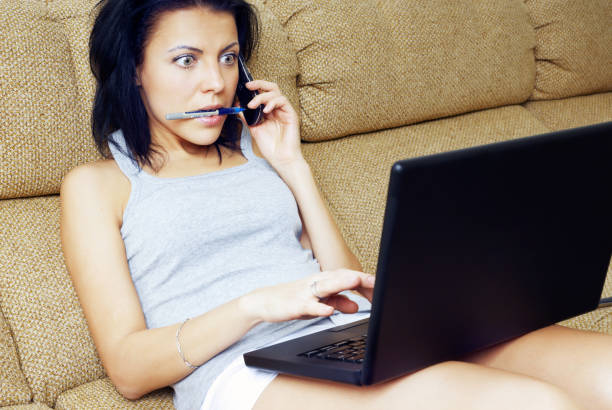 istock Busy woman talking on a cell phone while using a laptop 1321011376