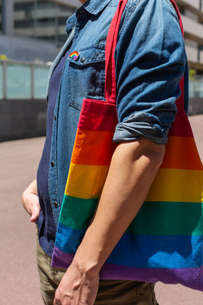 istock Man with rainbow reusable bag and lgbt badge, pride month 1321012340