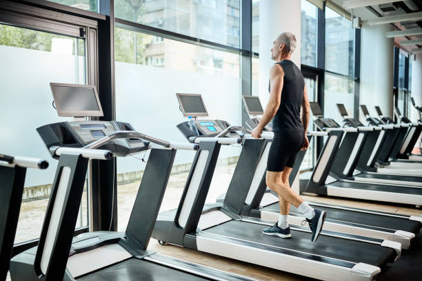istock Mature athletic man walking on treadmill while working out in a gym. 1321012730
