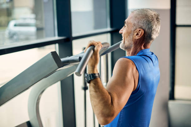 istock Happy mature sportsman doing pull-ups while exercising in a gym. 1321013389