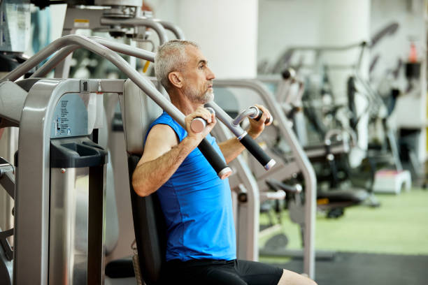 istock Mature athlete doing machine weight exercises for upper body strength in a gym. 1321013499